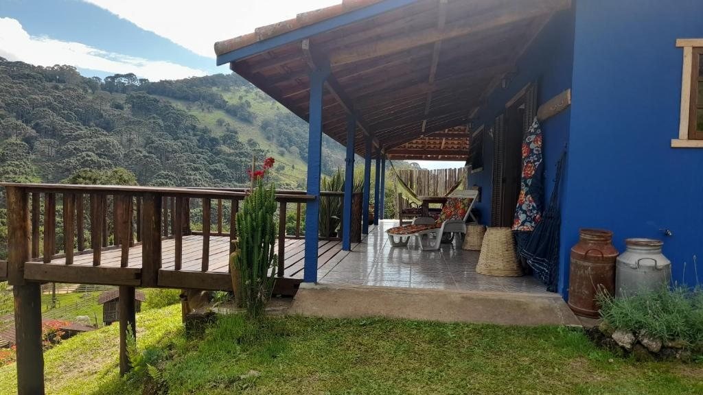 Varanda da Casinha Azul com deck de madeira e vista para as montanhas